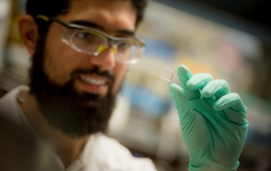 Closeup of a UCSD researcher looking at microscope slide