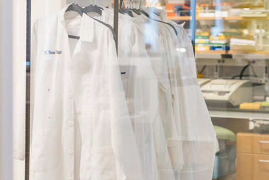white lab coats hanging in a lab
