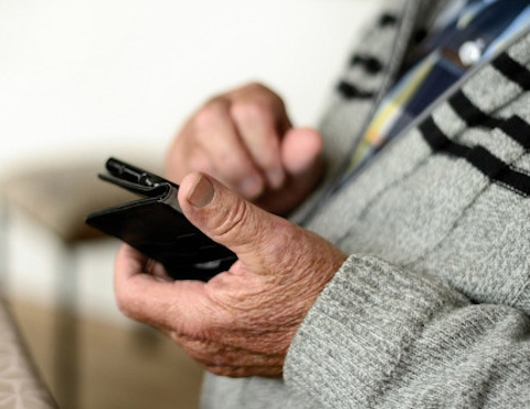 elderly person holding mobile